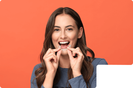 An adult woman smiling with straight white teeth after finishing Spark Aligners treatment.