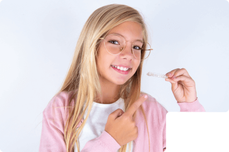 An little girl smiling with straight white teeth after finishing Invisalign Aligners treatment.