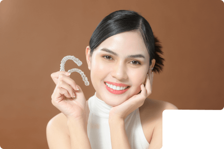 An teen girl smiling with straight white teeth after finishing Invisalign Aligners treatment.