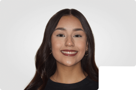 A teen girl smiling with straight white teeth after finishing metal braces.