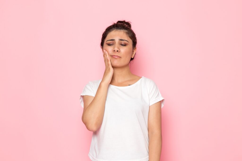 A woman experiencing TMJ pain and considering myofunctional therapy.