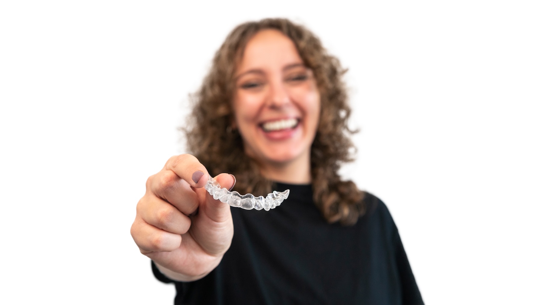 Happy woman holding clear aligner tray.