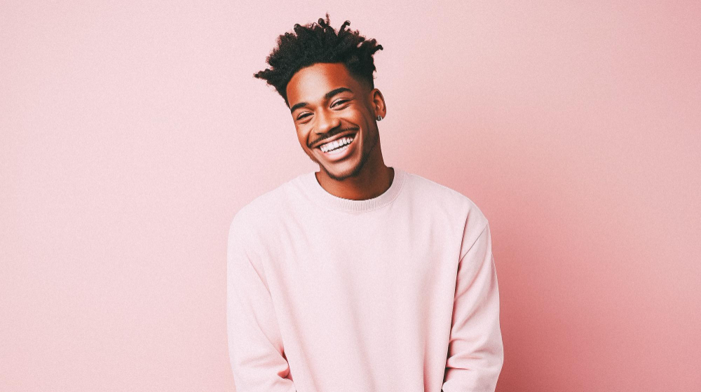 Smiling African American man in a pink shirt.