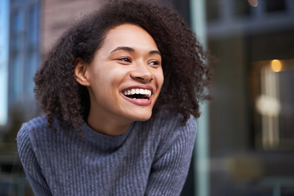 Smiling woman in a gray sweater.