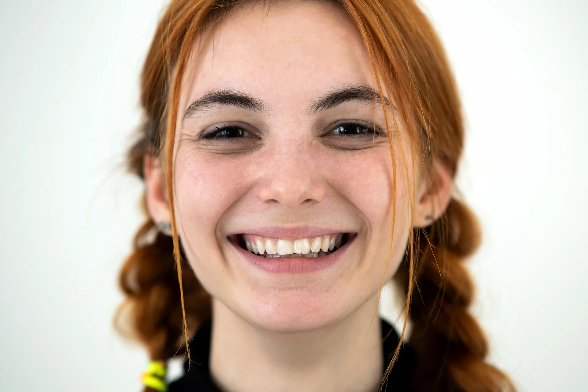 Smiling redheaded girl with slightly crooked front teeth.